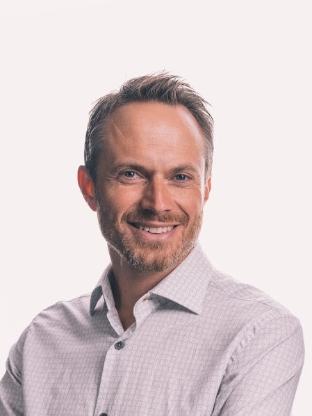 En mann med skjegg som smiler