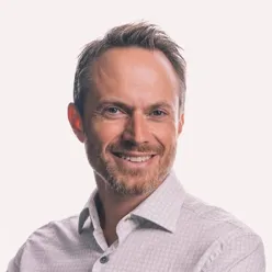 En mann med skjegg som smiler