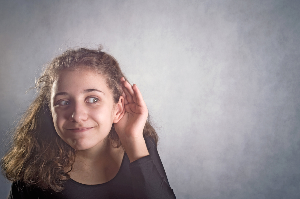 Jente som lyttar ved å halde seg ved øyret