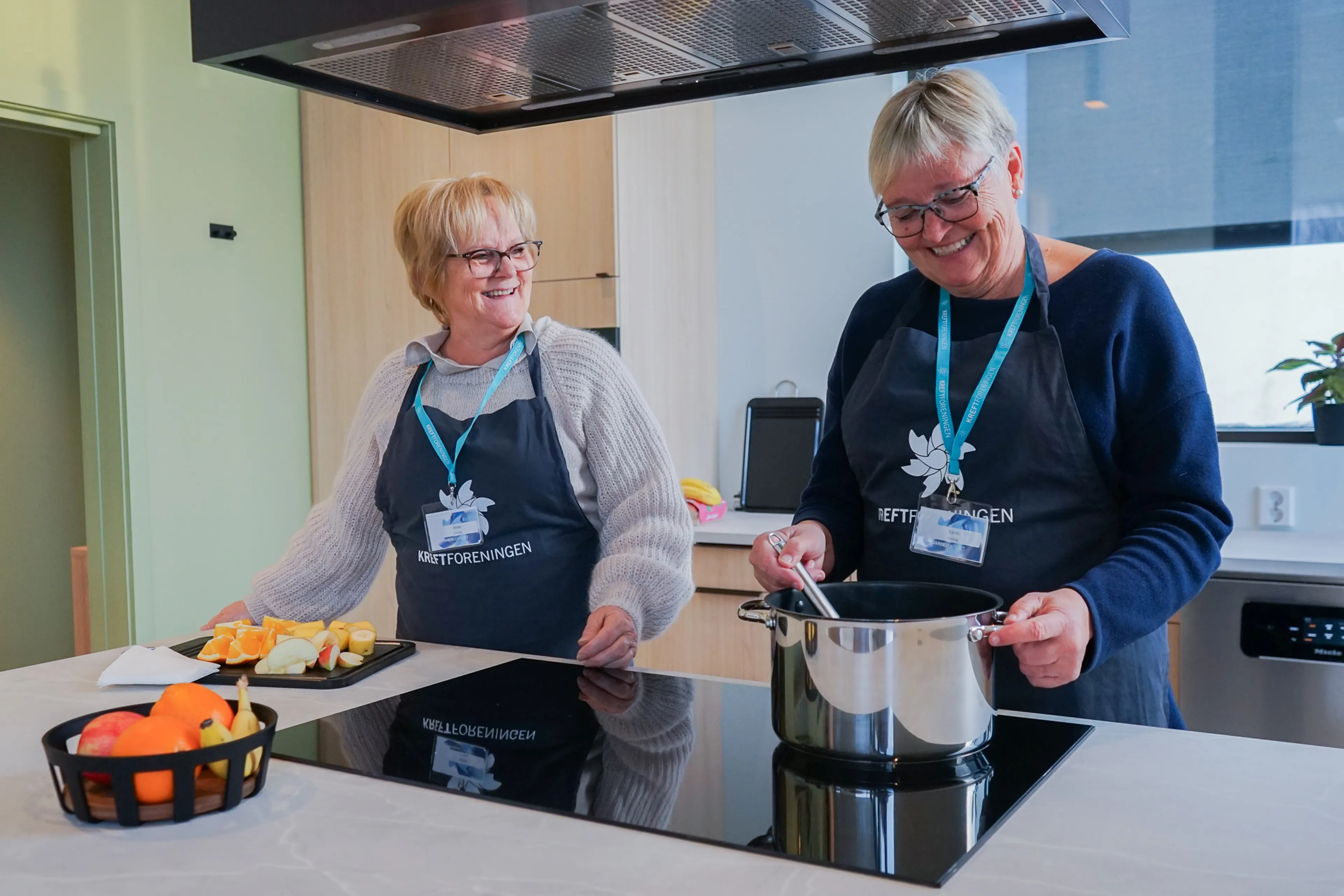 Et par kvinner som lager mat på et kjøkken