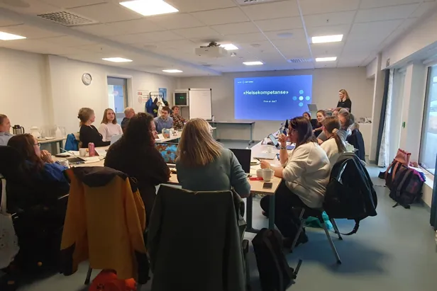 En gruppe mennesker som sitter i et rom