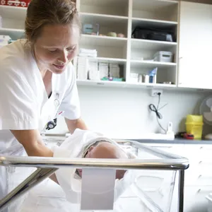 En ansatt på fødeavdelinga med en baby