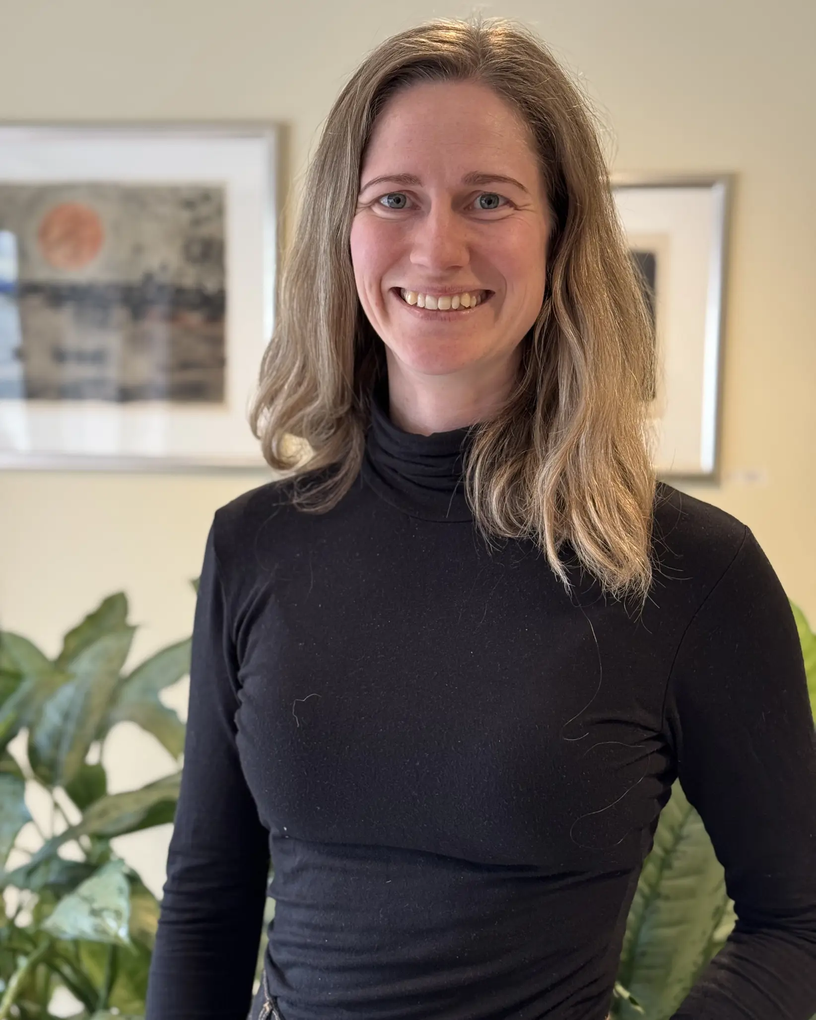 En kvinne som smiler til kameraet