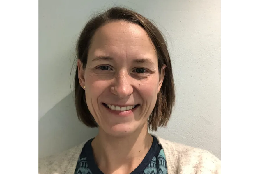 En kvinne som smiler til kameraet