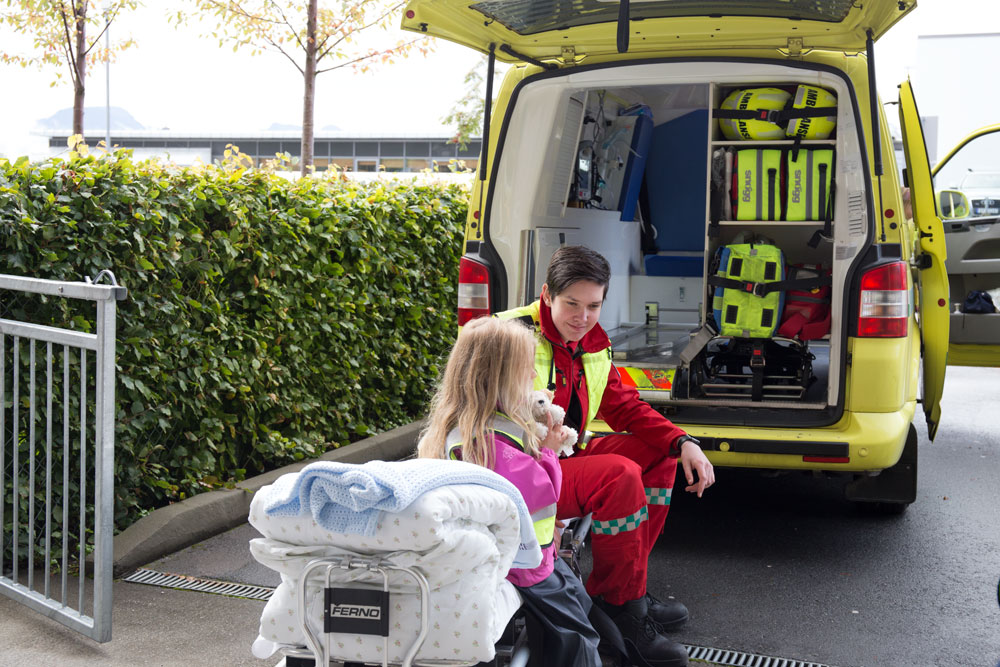 En person og en jente som sitter på en stol utenfor en gul lastebil