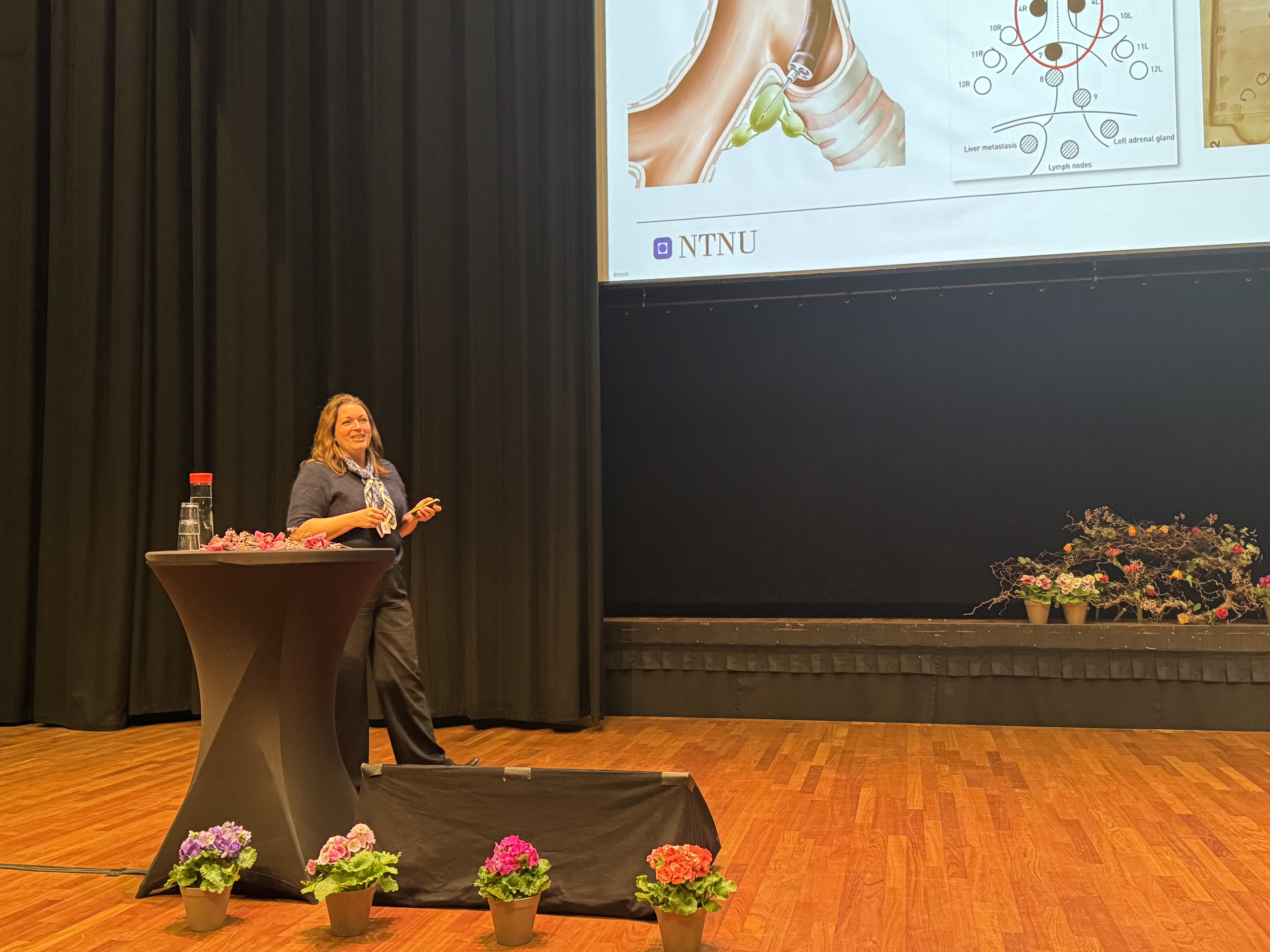 En kvinne som står ved en talerstol på en scene