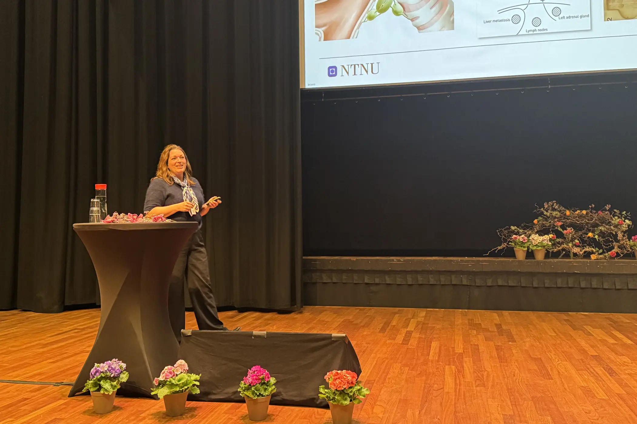 En kvinne som står ved en talerstol på en scene