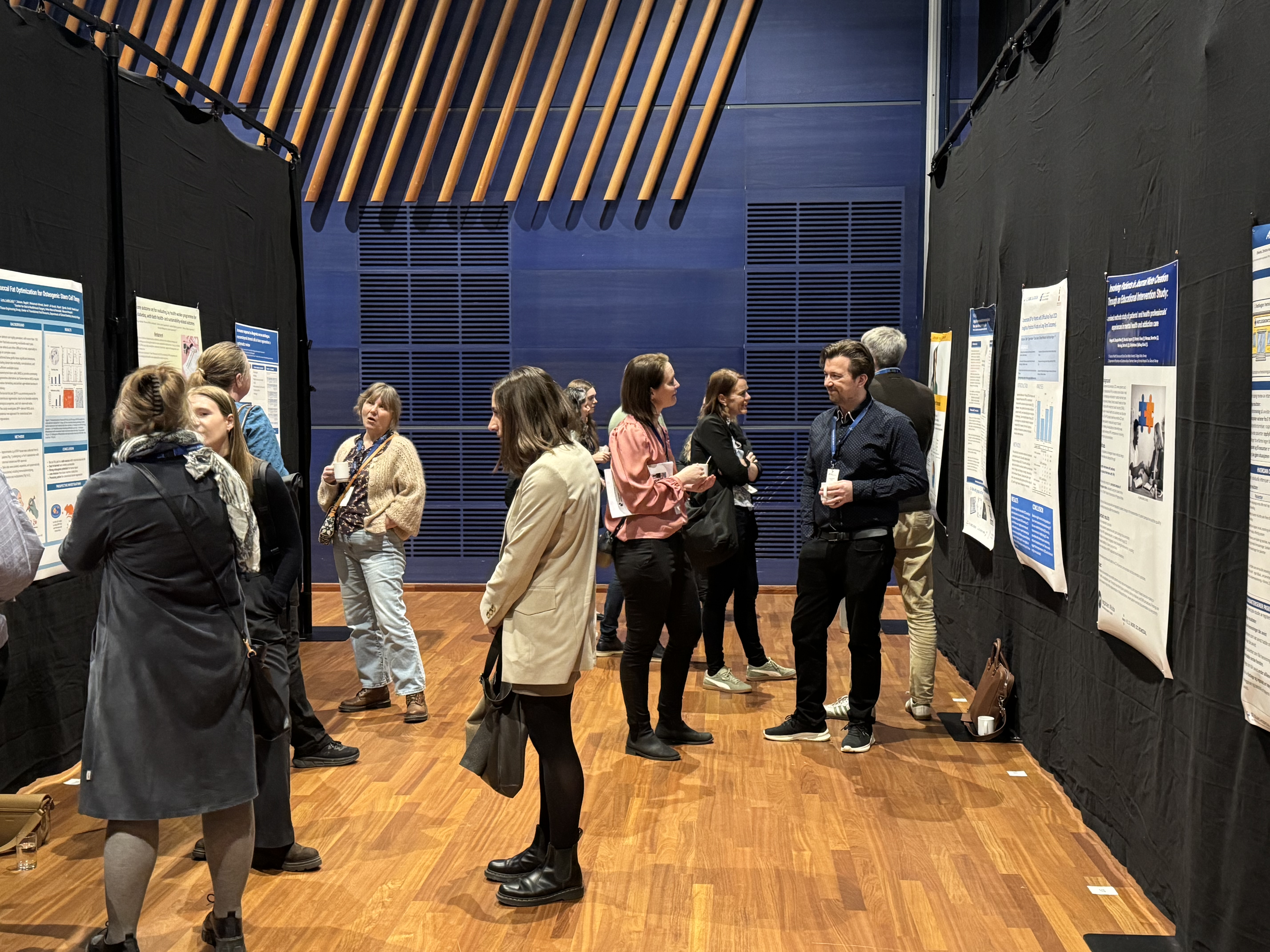 En gruppe mennesker foran vegger med postere