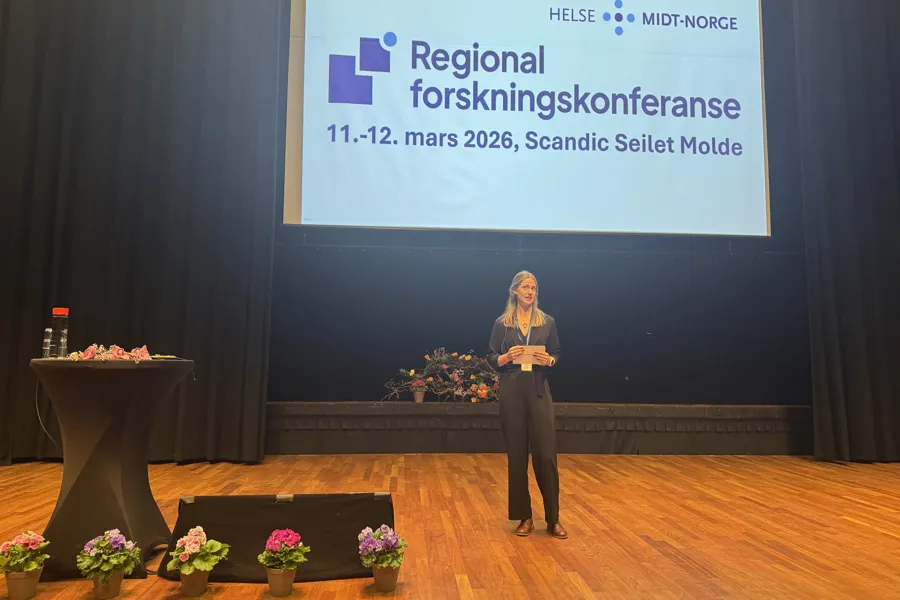 En kvinne står på en scene