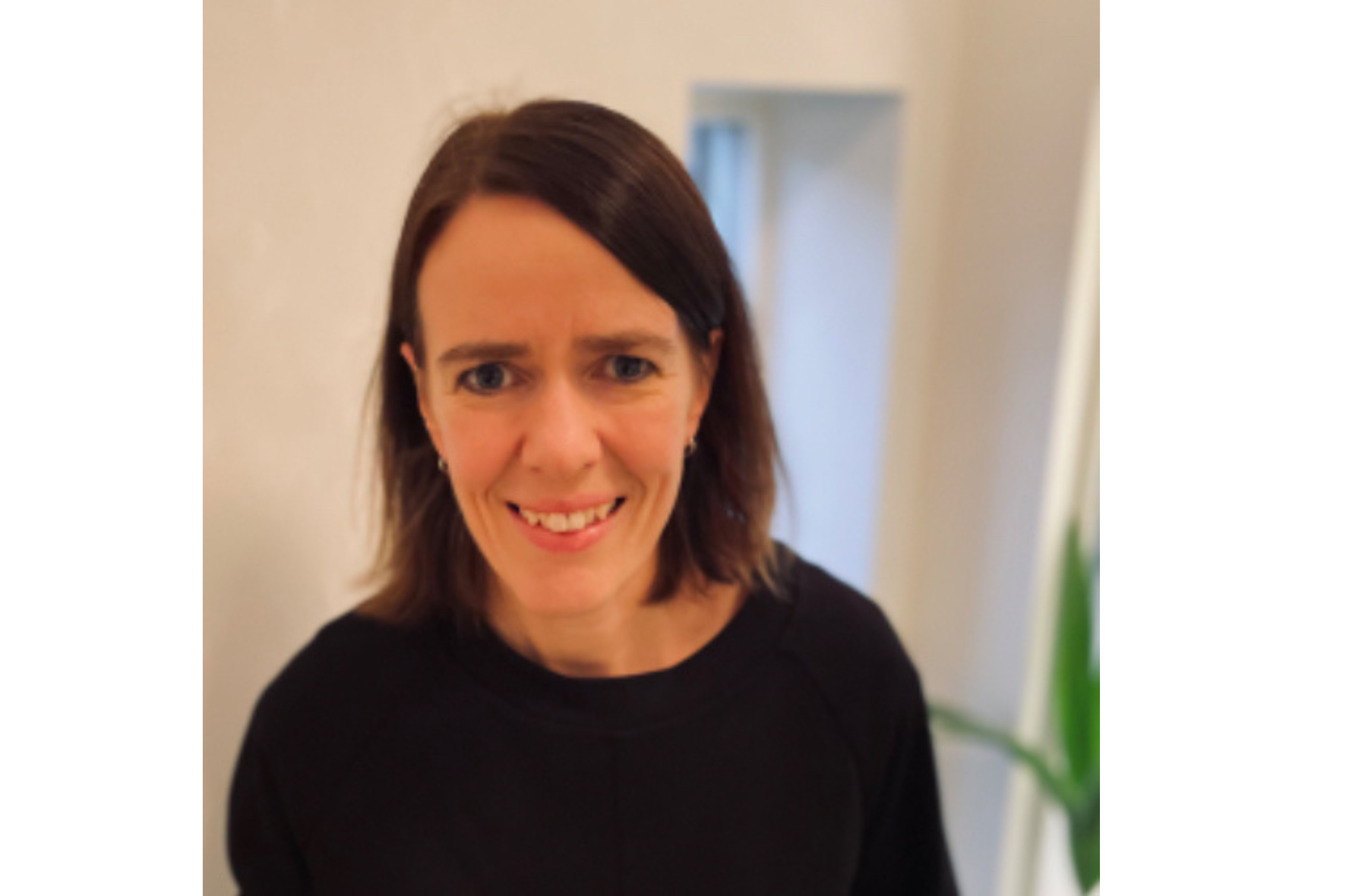 En kvinne som smiler til kameraet