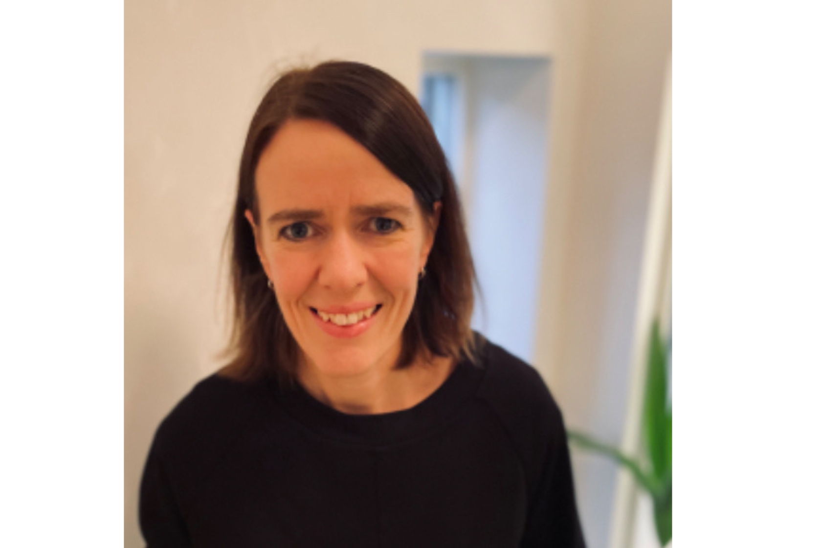 En kvinne som smiler til kameraet