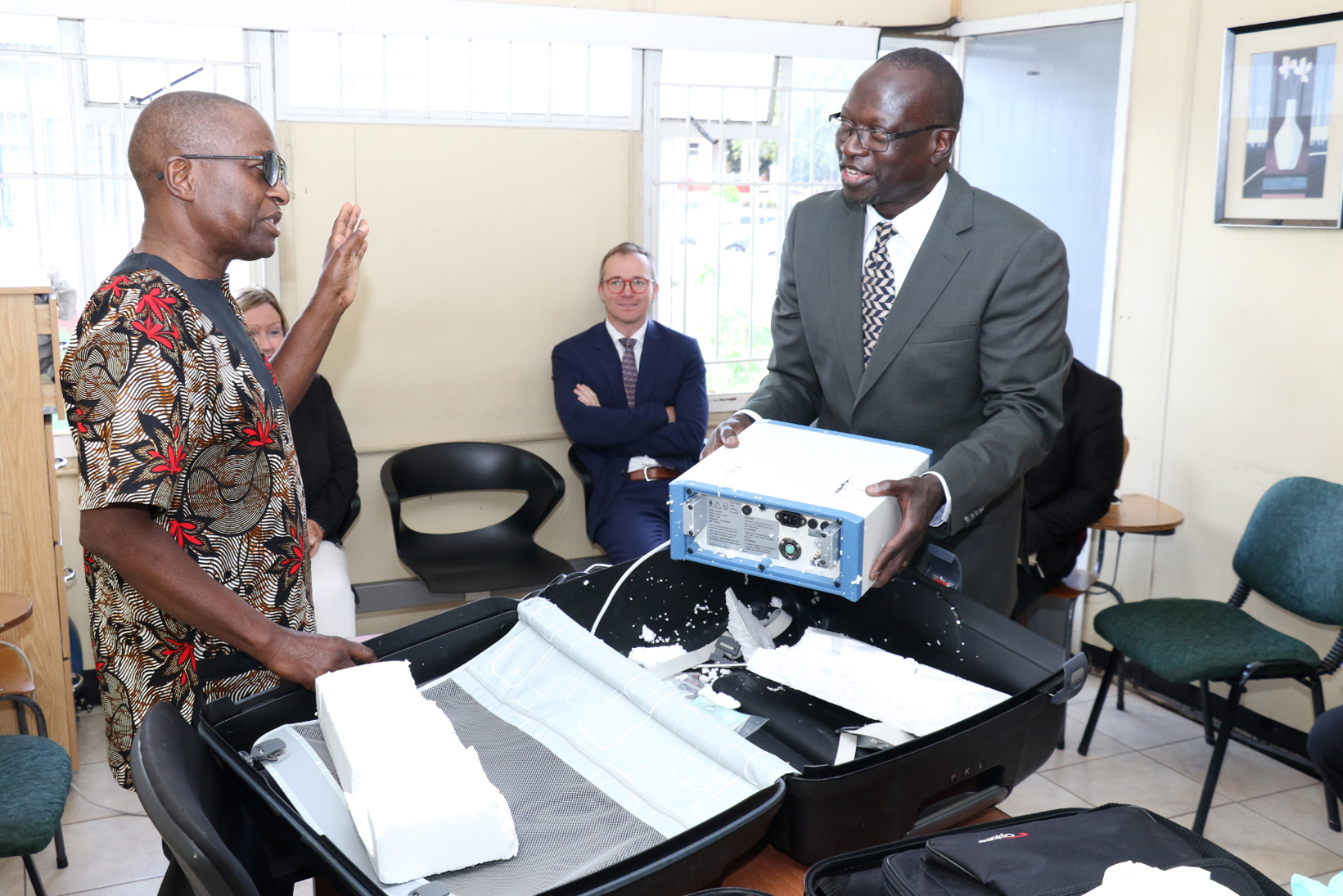 En mann som står ved siden av en mann som holder en eske