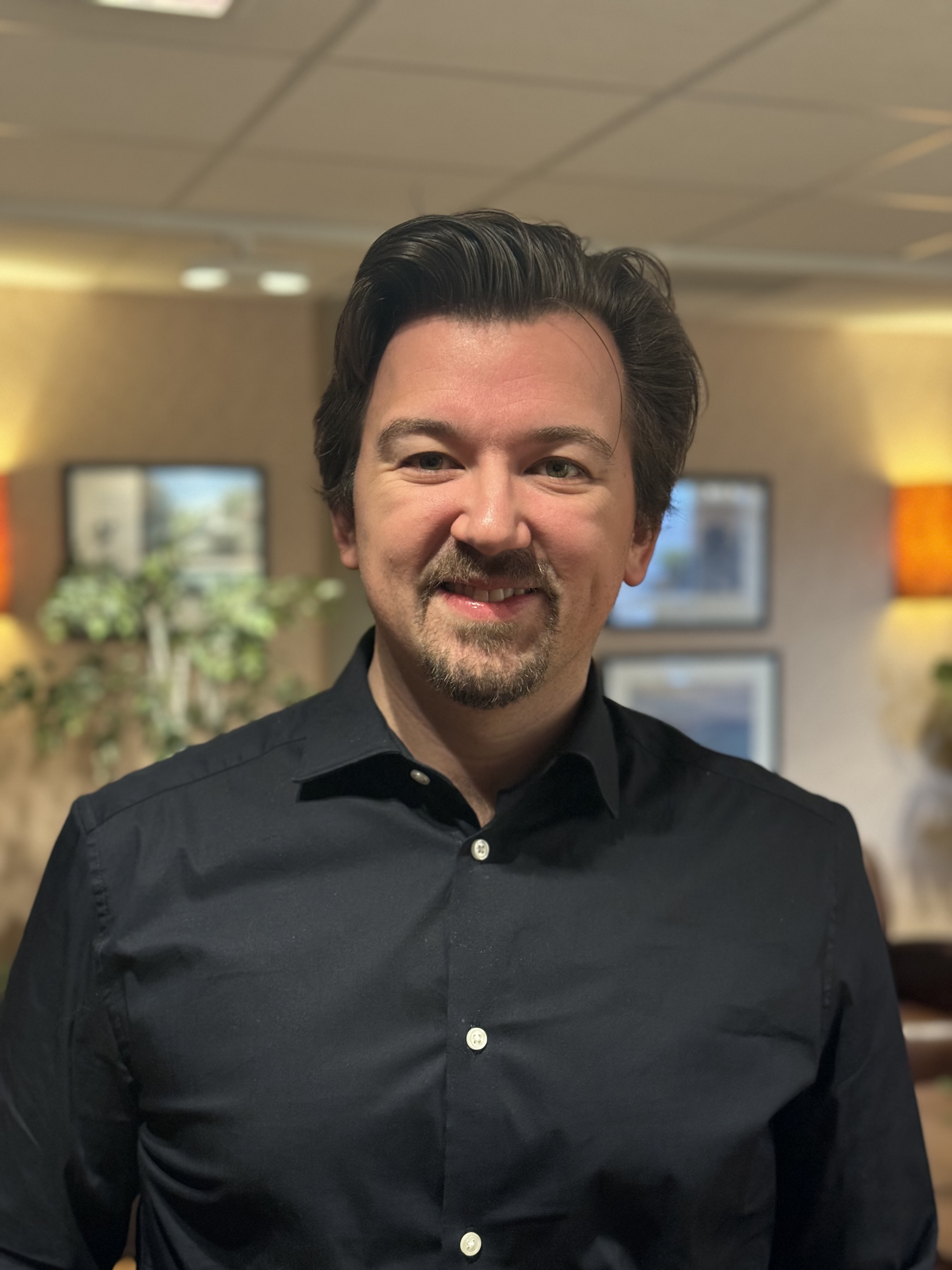 En mann som smiler til kameraet