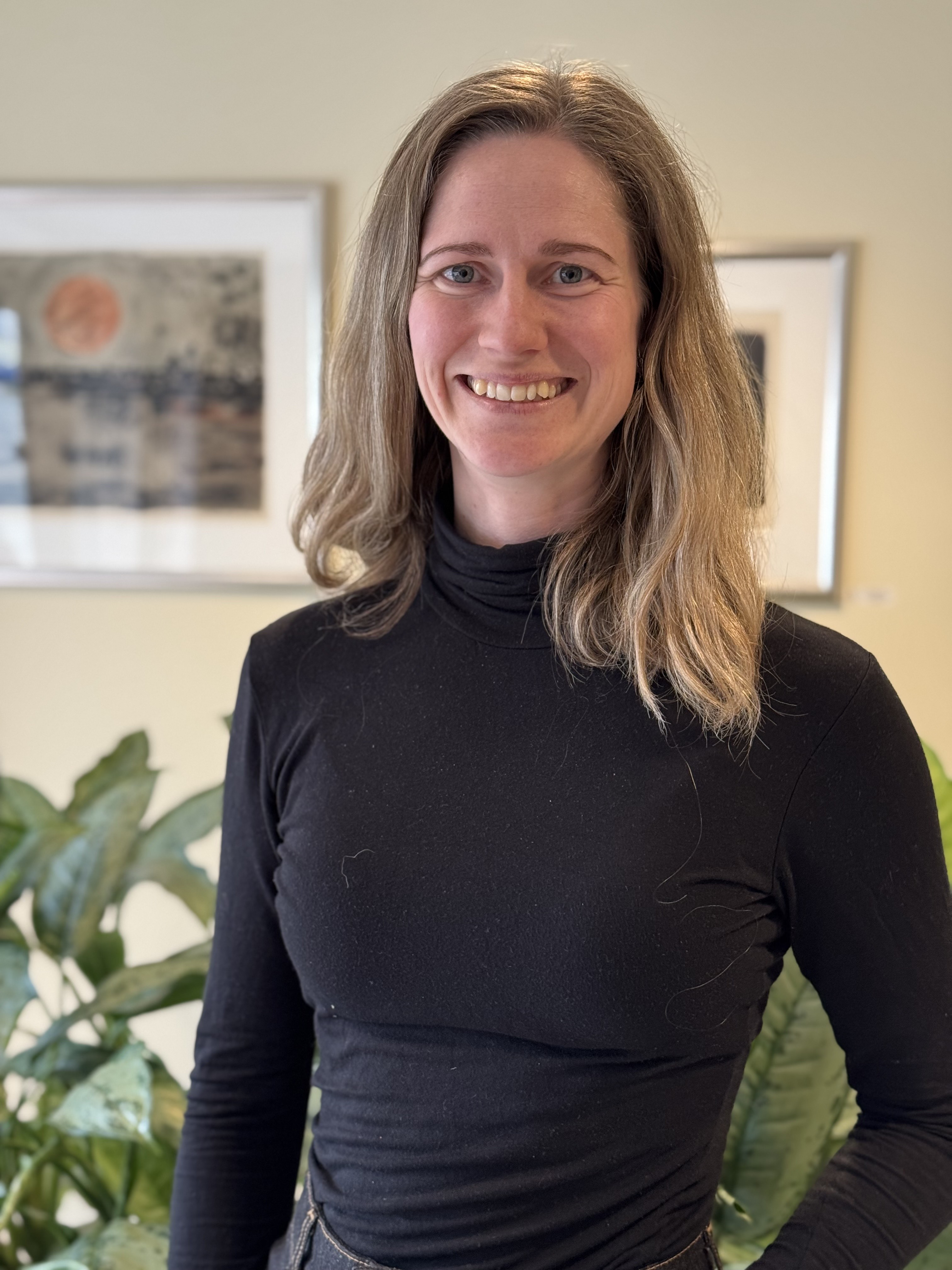 En kvinne som smiler til kameraet