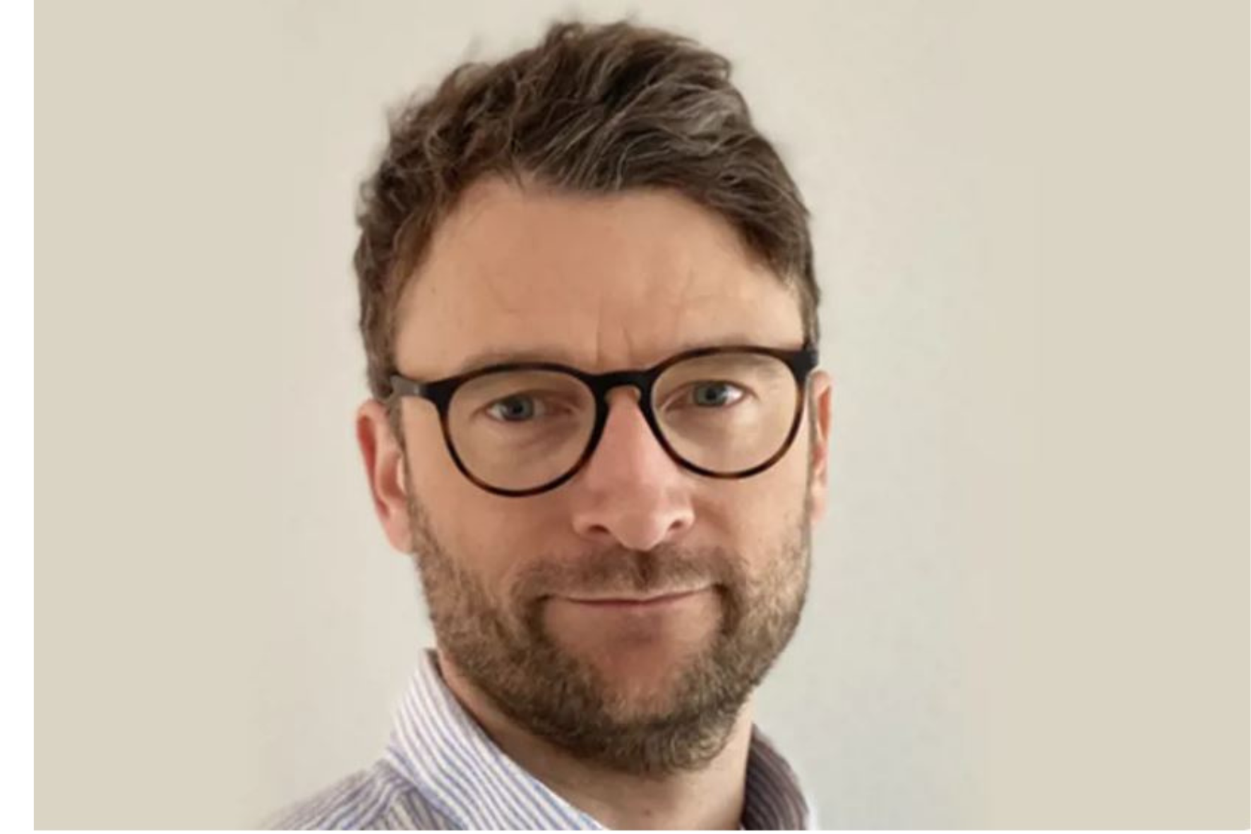 En mann med briller som smiler