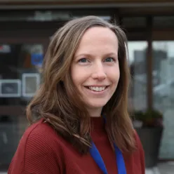 En kvinne som smiler til kameraet