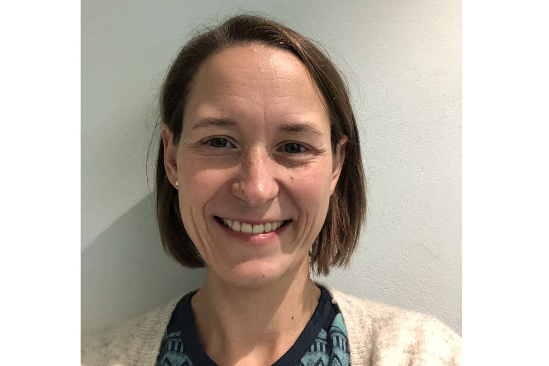 En kvinne som smiler til kameraet