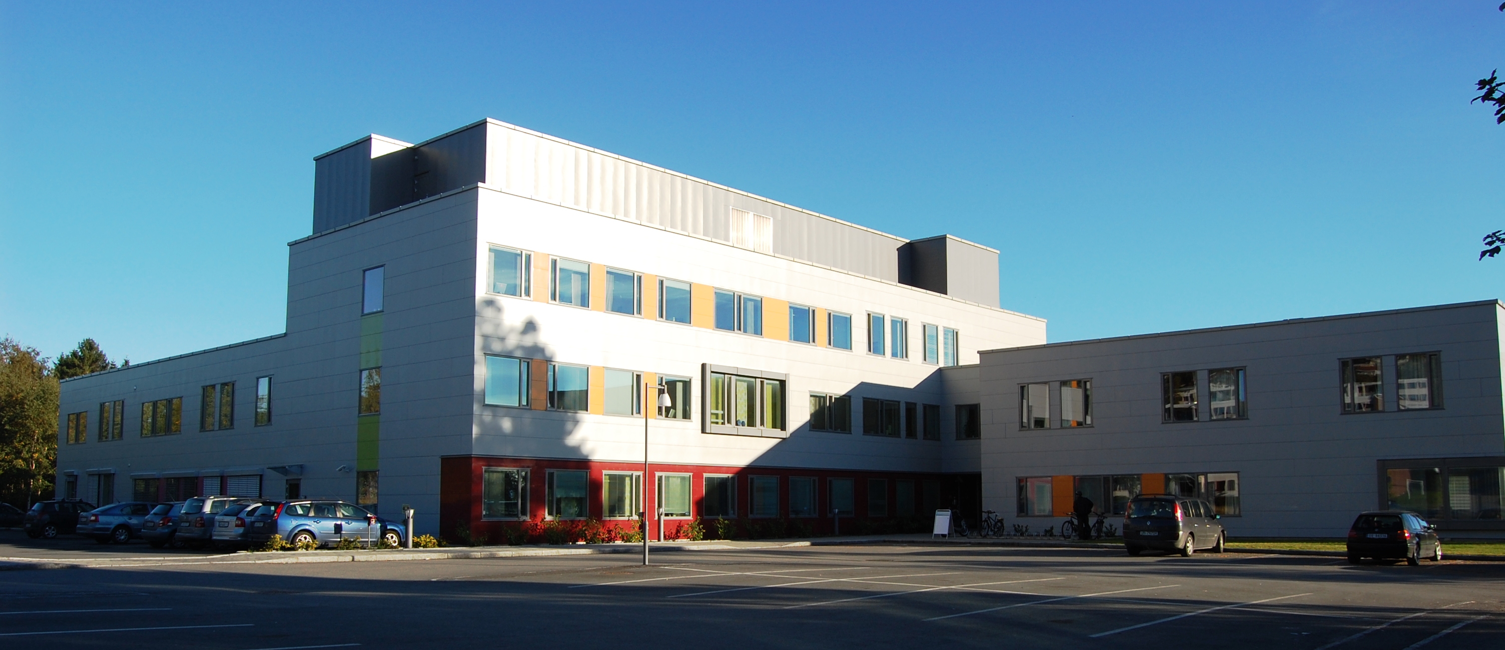 En bygning med biler parkert foran