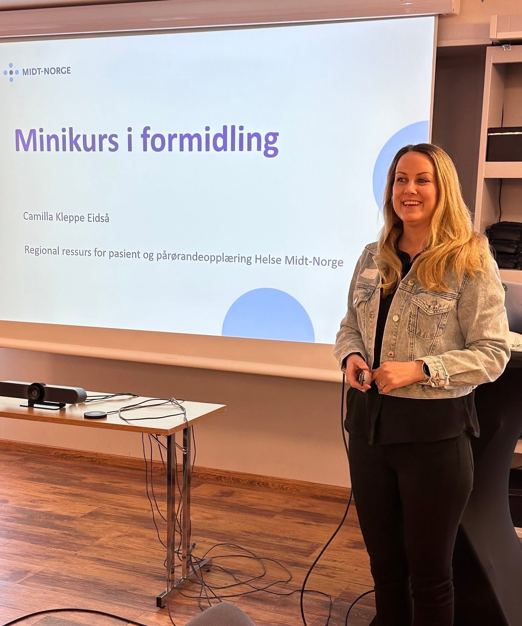 En kvinne som står foran en projektorskjerm