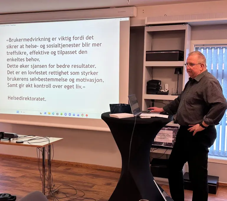 En person som står foran en projektorskjerm