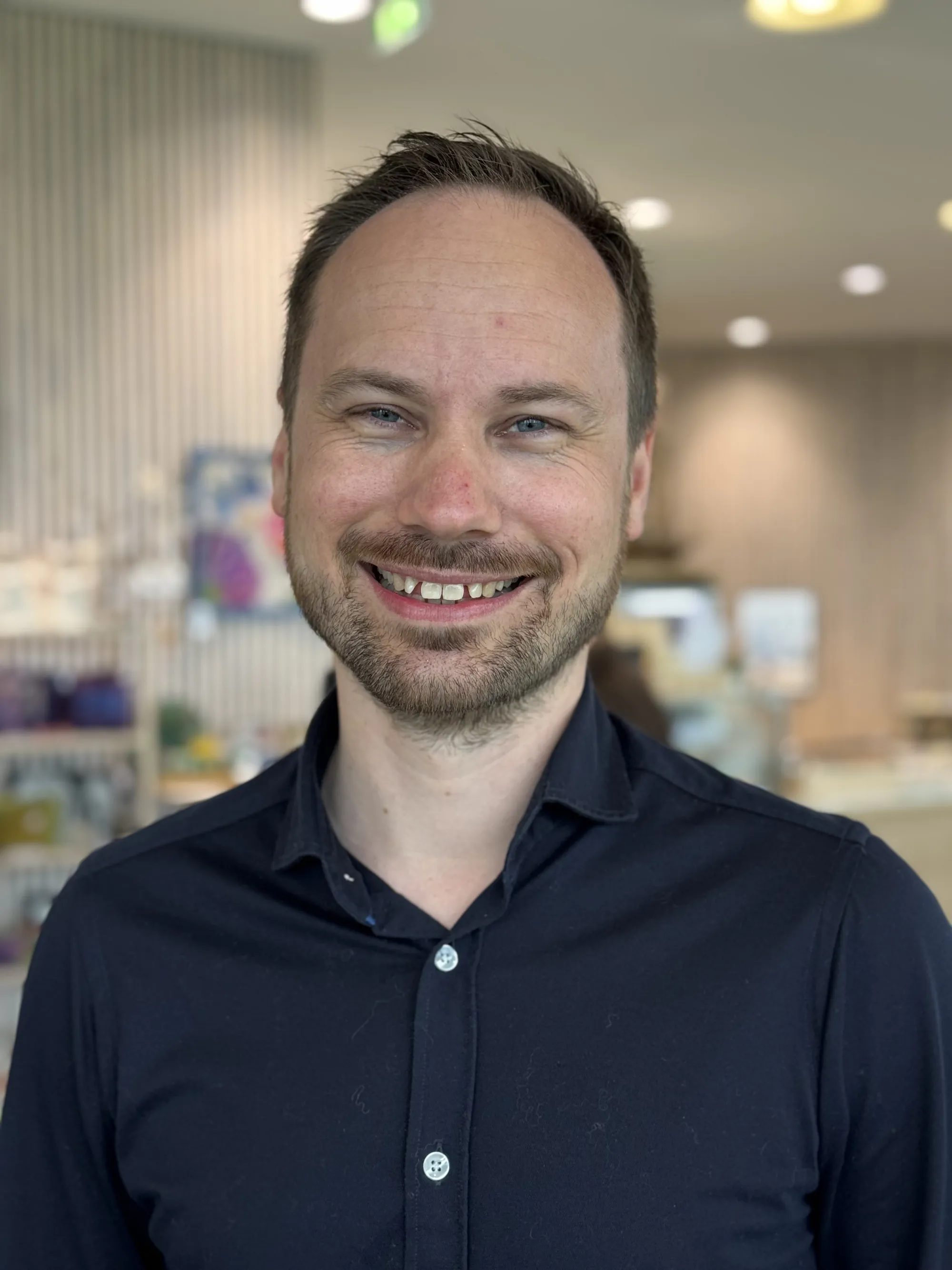 En mann som smiler til kameraet