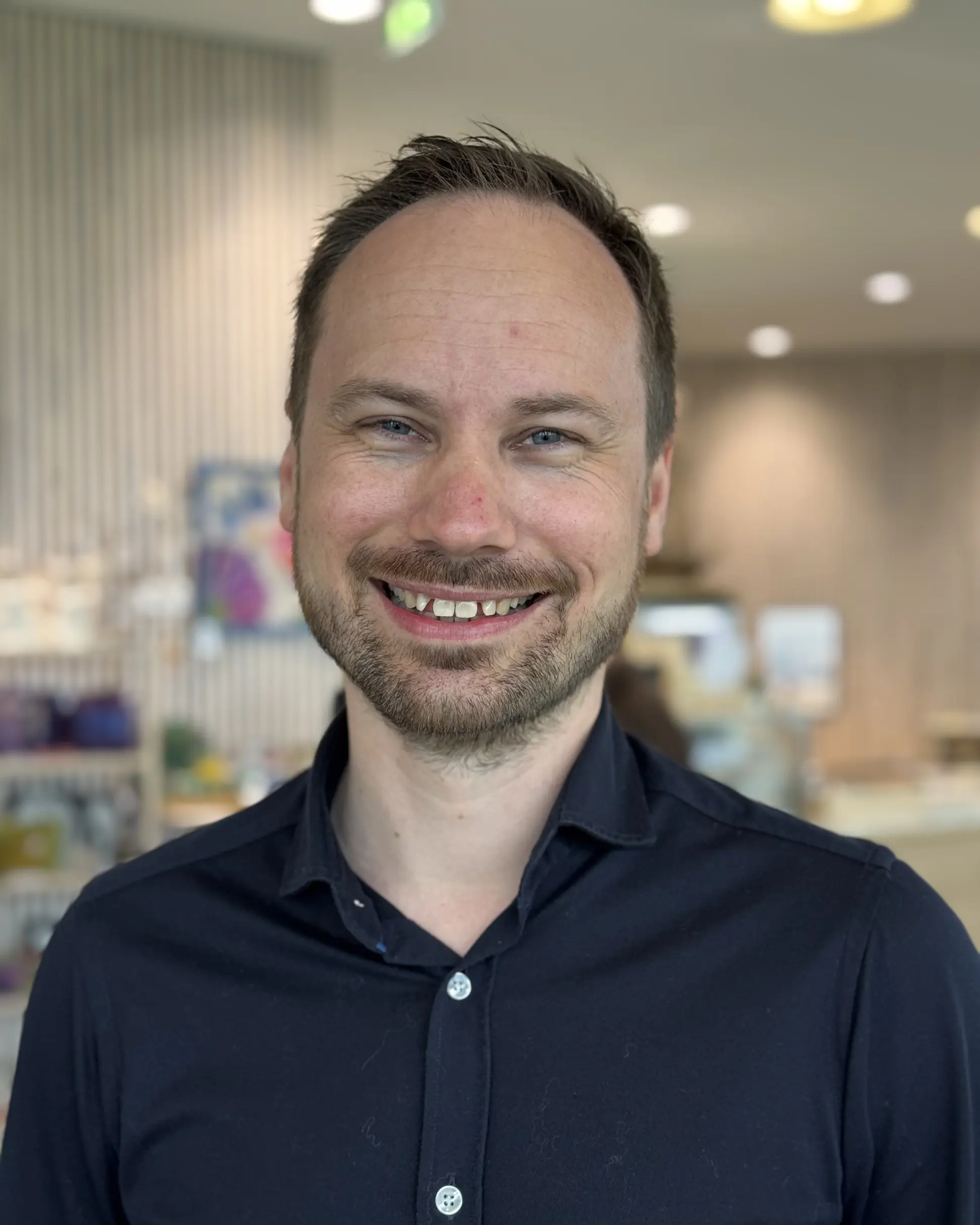 En mann som smiler til kameraet