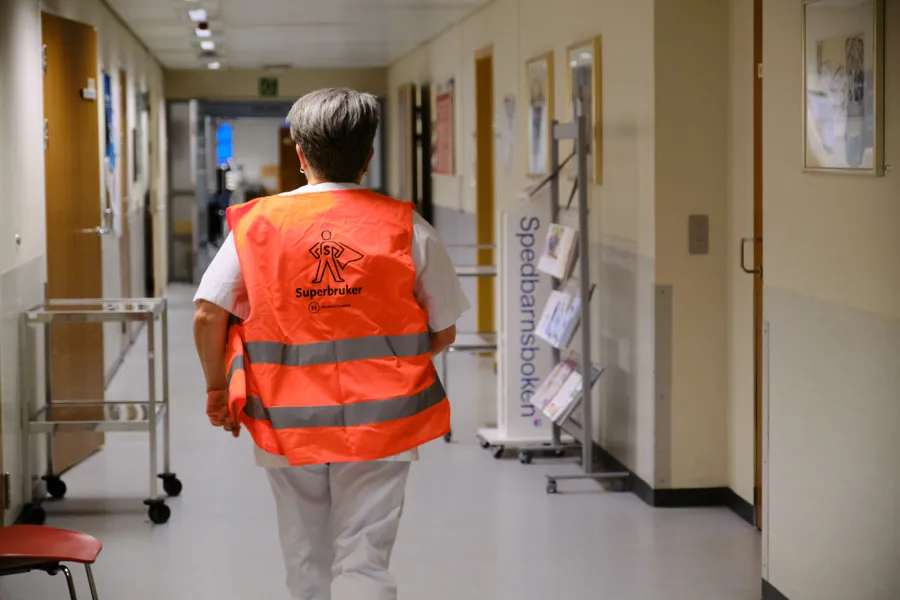 En mann iført oransje vest