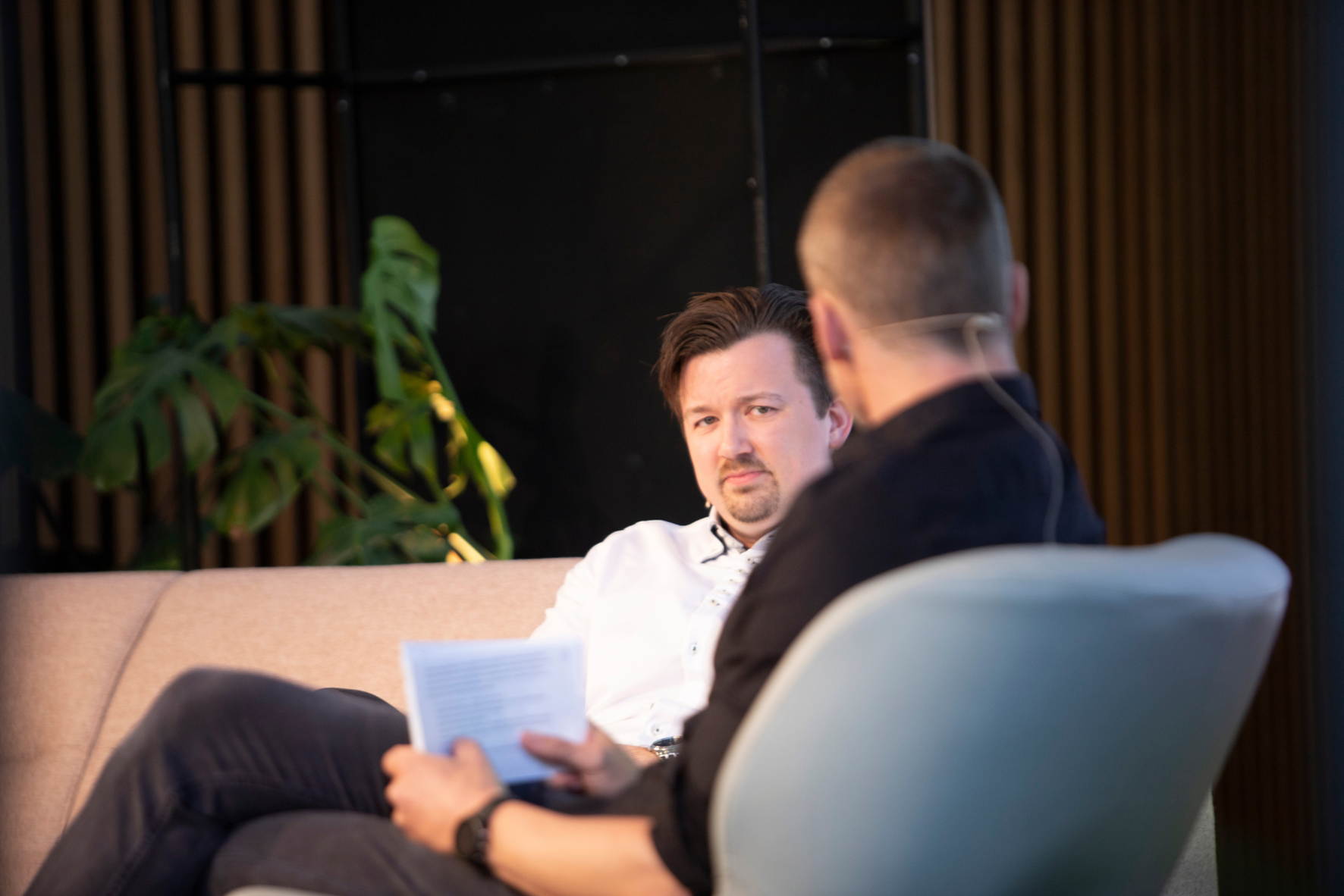 En mann som sitter ved siden av en annen mann