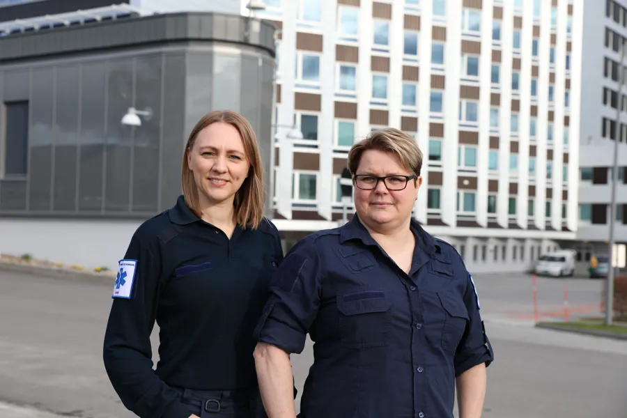 En mann og kvinne som poserer for et bilde foran en bygning