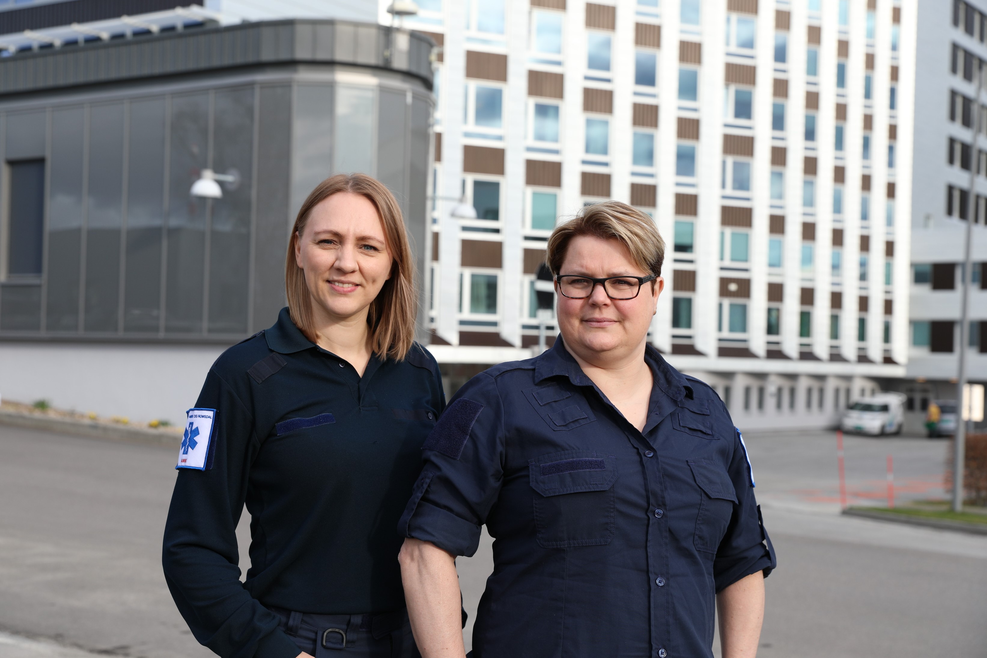 En mann og kvinne som poserer for et bilde foran en bygning