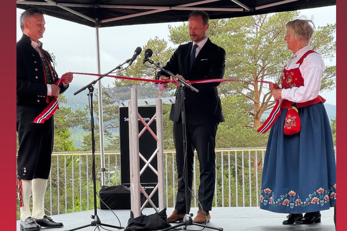 En mann i dress og slips som står ved siden av en kvinne i kjole