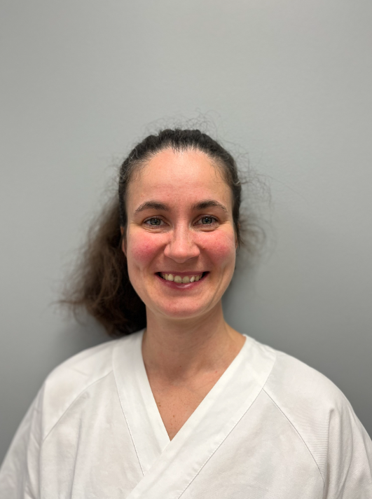 En kvinne som smiler til kameraet