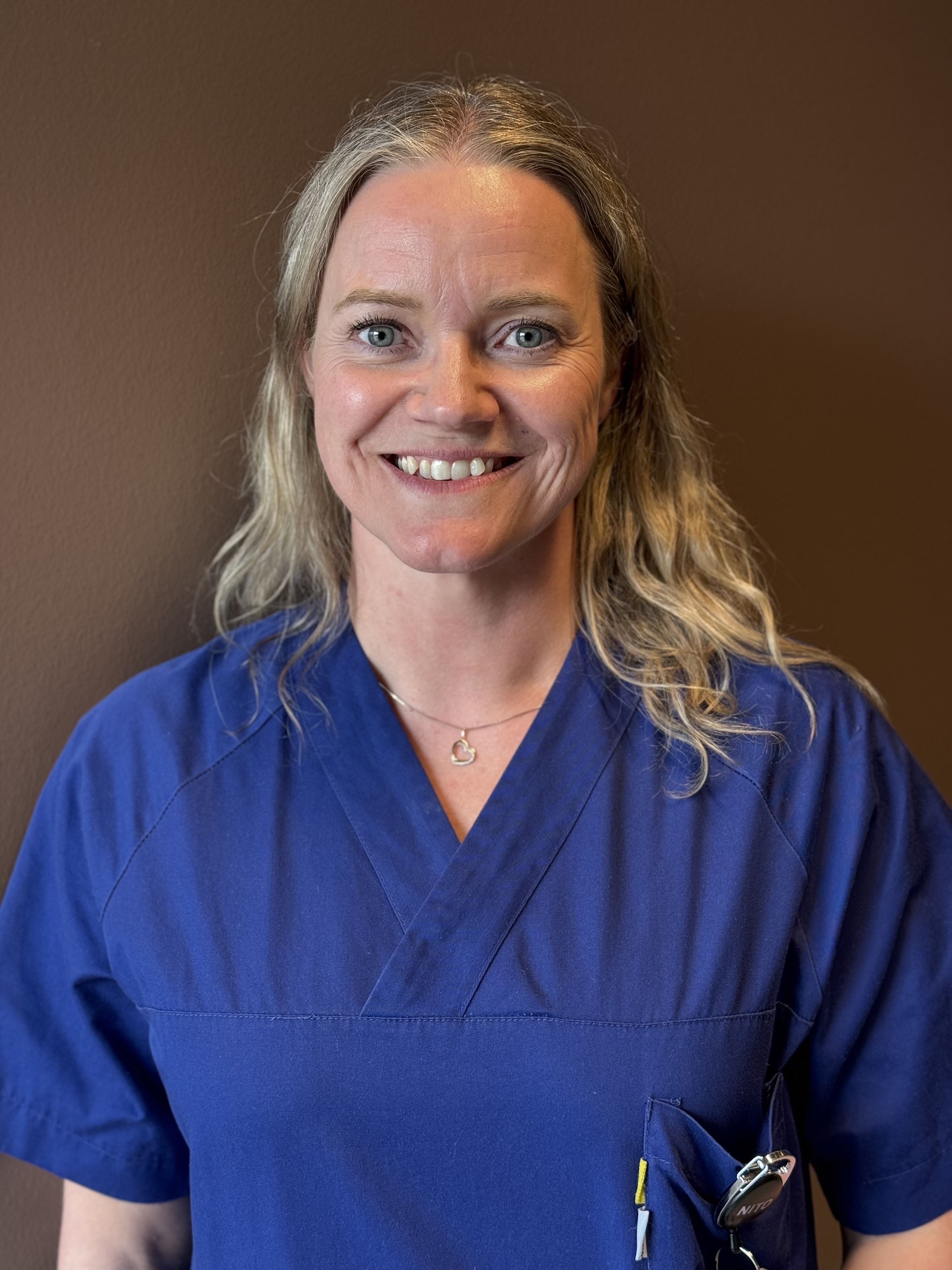 En kvinne som smiler til kameraet