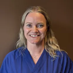 En kvinne som smiler til kameraet