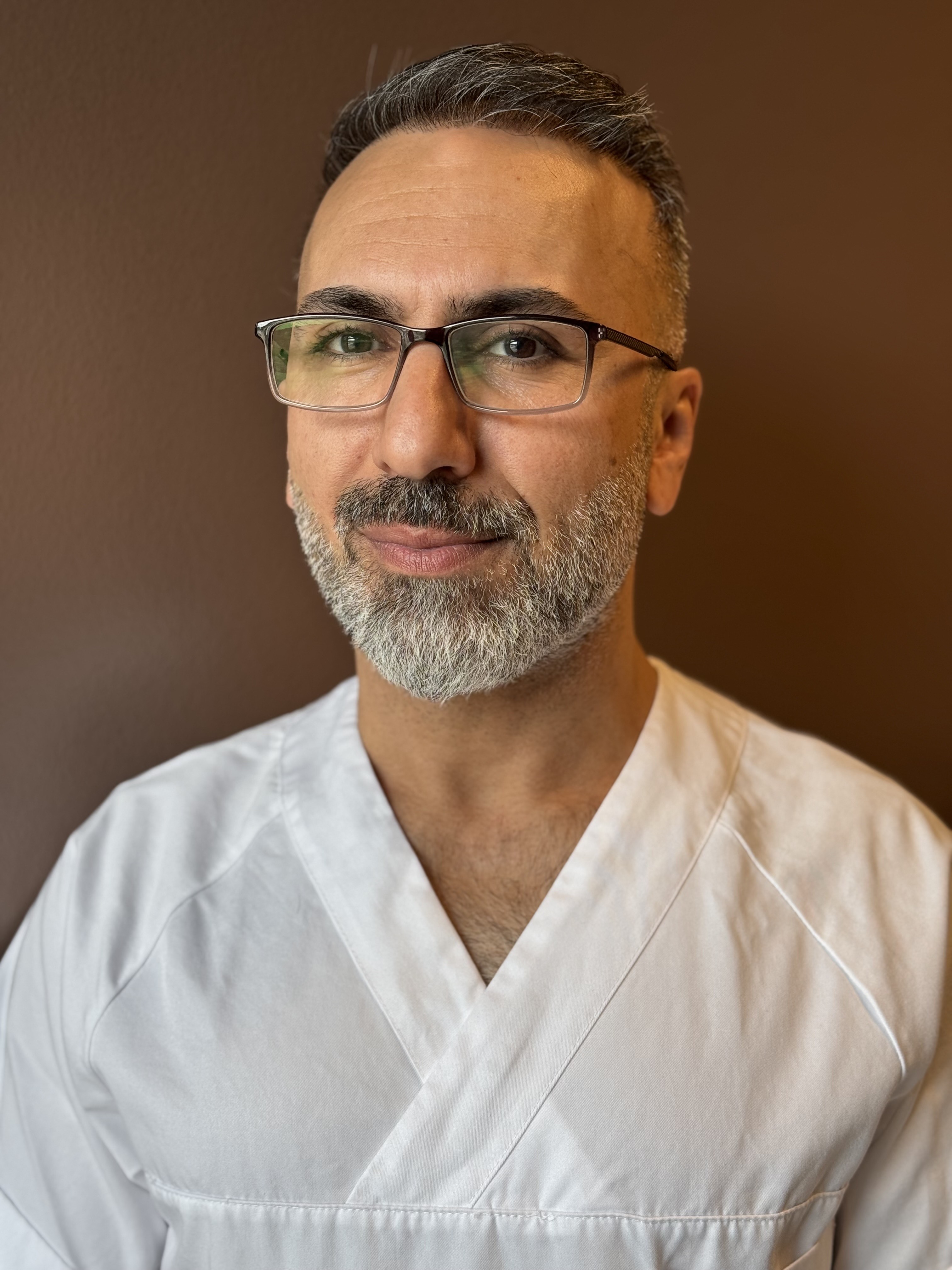 En mann med skjegg og briller