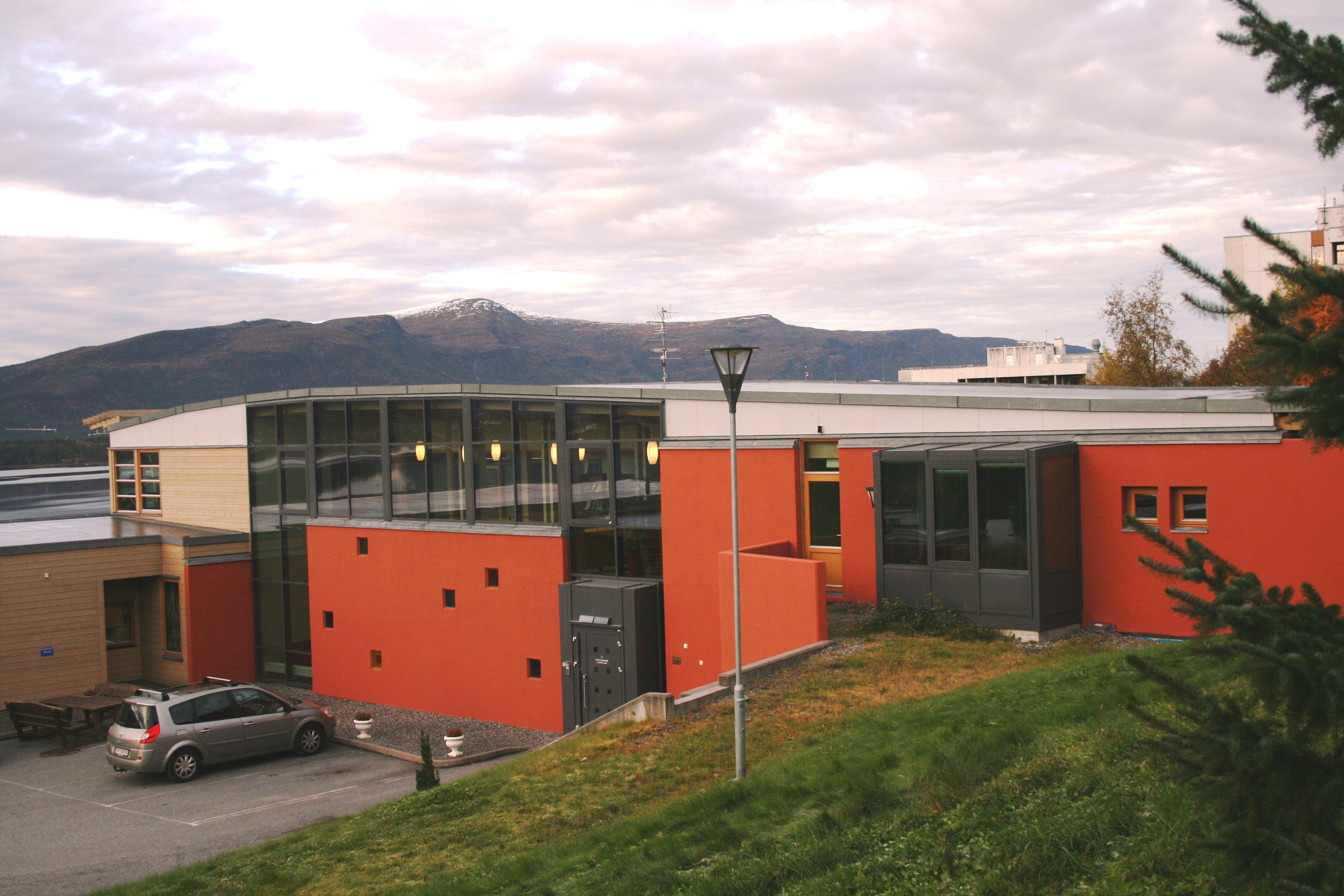 Et rødt bygg med parkeringsplass