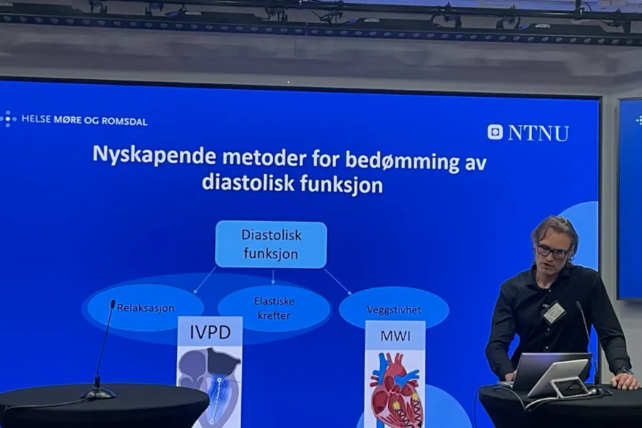 En mann som står ved et podium med en bærbar datamaskin