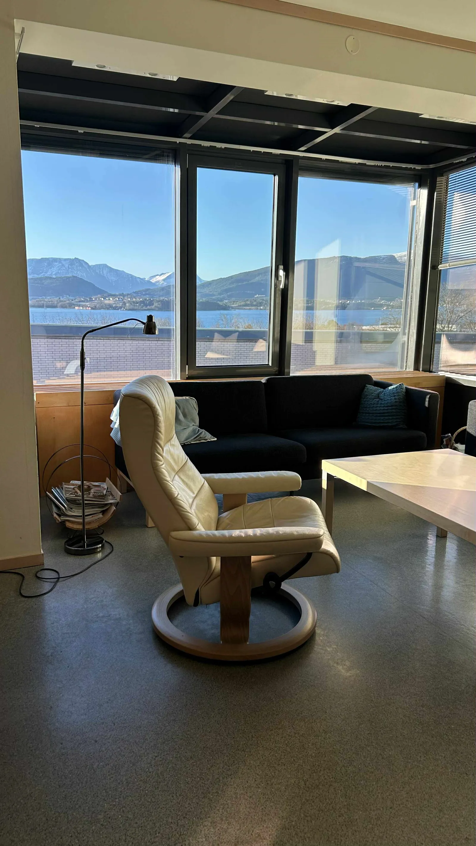 Et rom med sofa og bord med utsikt over vannet