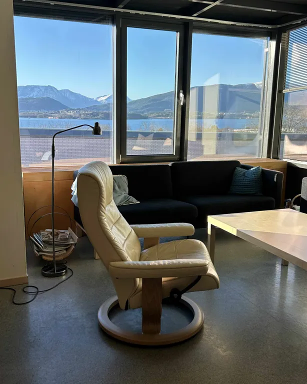 Et rom med sofa og bord med utsikt over vannet