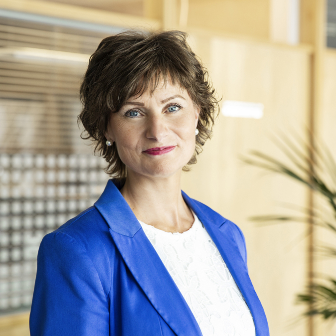 Ei kvinne som smiler til kameraet