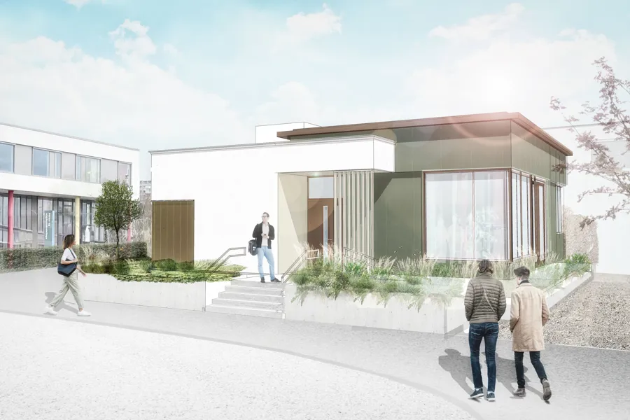 Eit bygg med flatt tak, kvit og lys brun fasade, store vindauge og beplantning rundt.