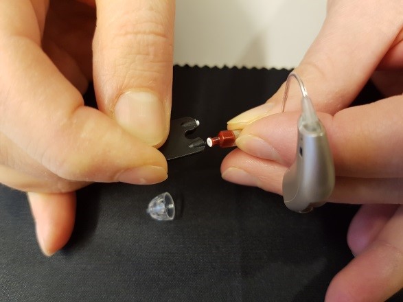 En person som holder en liten metallgjenstand