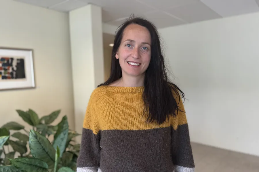 En kvinne som smiler til kameraet