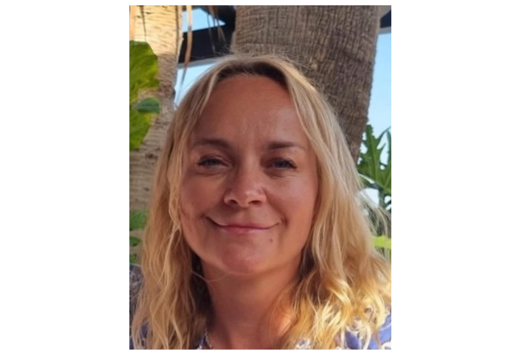 En kvinne som smiler til kameraet