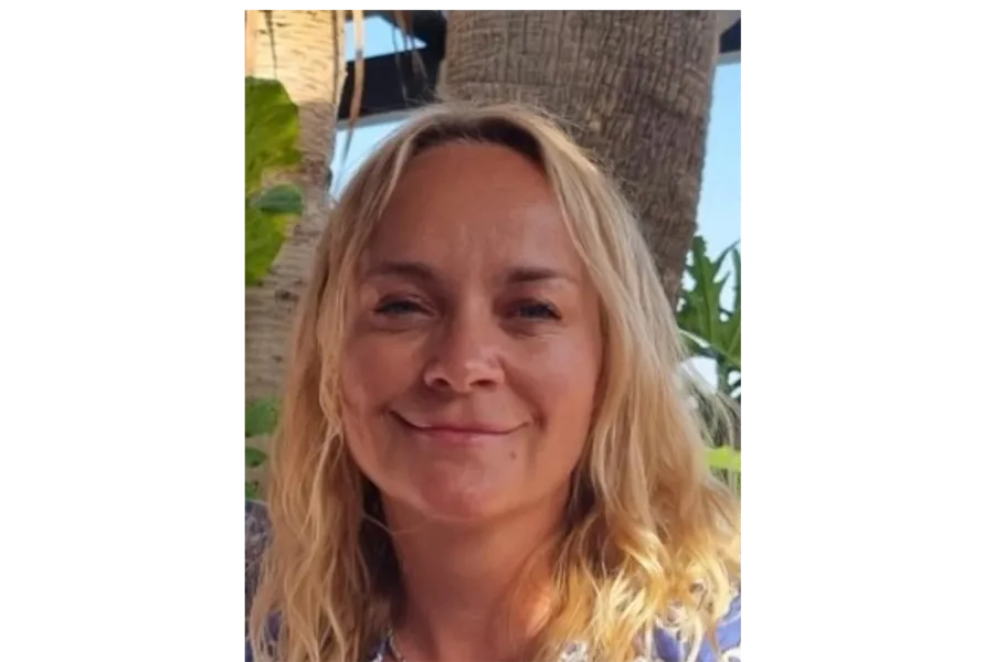 En kvinne som smiler til kameraet