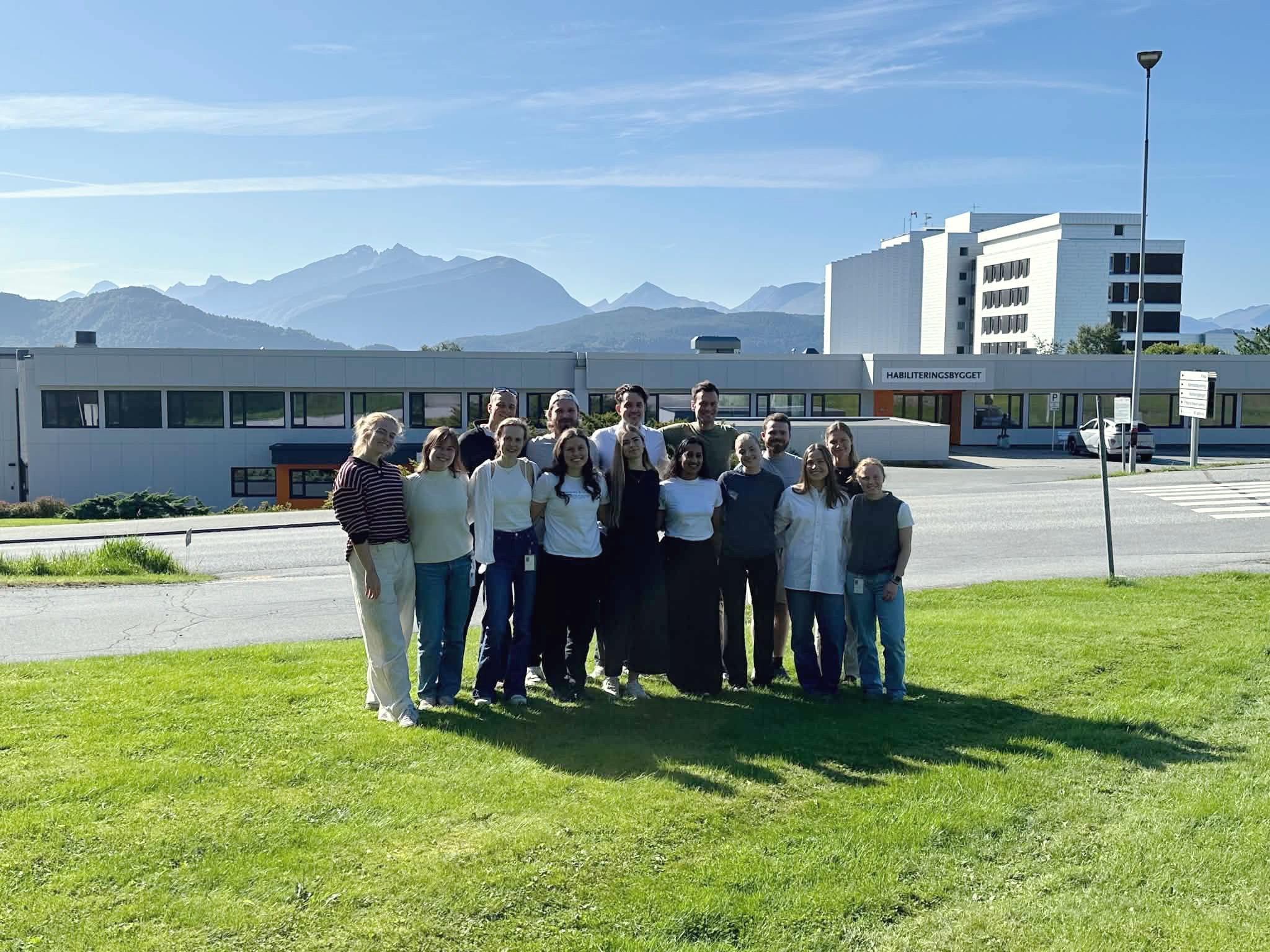 En gruppe mennesker som poserer for et bilde foran en bygning