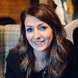 En kvinne som smiler til kameraet