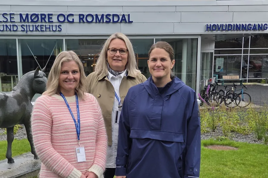 En gruppe kvinner som poserer for et bilde foran en bygning