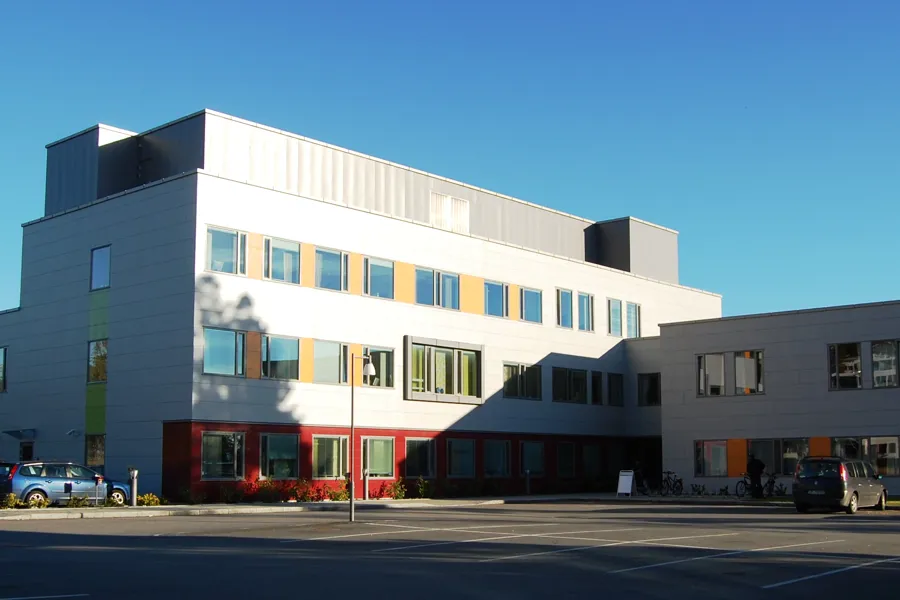 En bygning med biler parkert foran