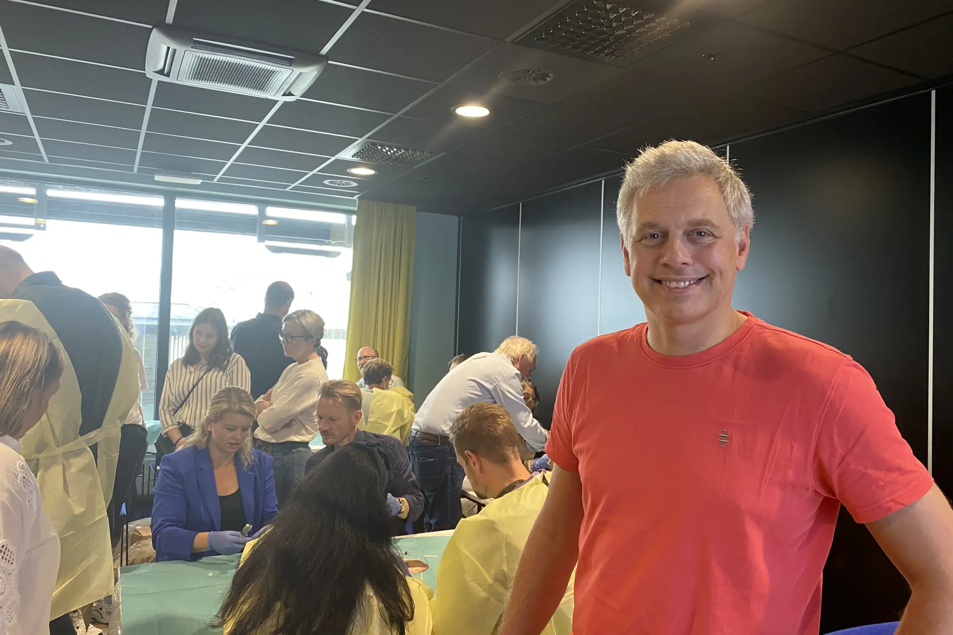 En person som står i et rom med andre mennesker